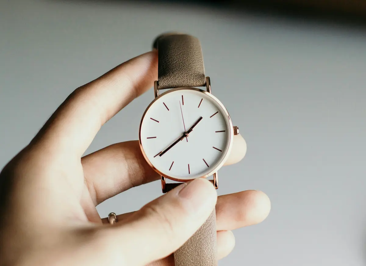 Person holding an analog wristwatch