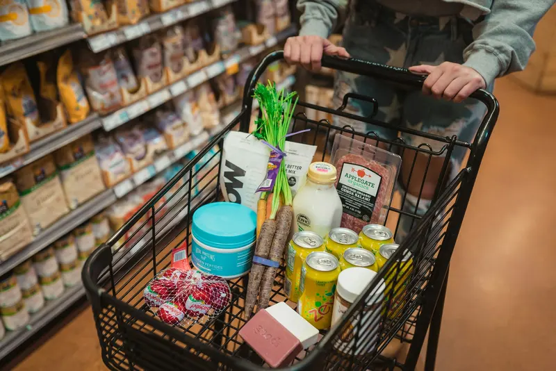 Groceries in a shopping cart in a supermarket aisle