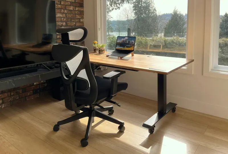 A tidy home office desk in front of a window