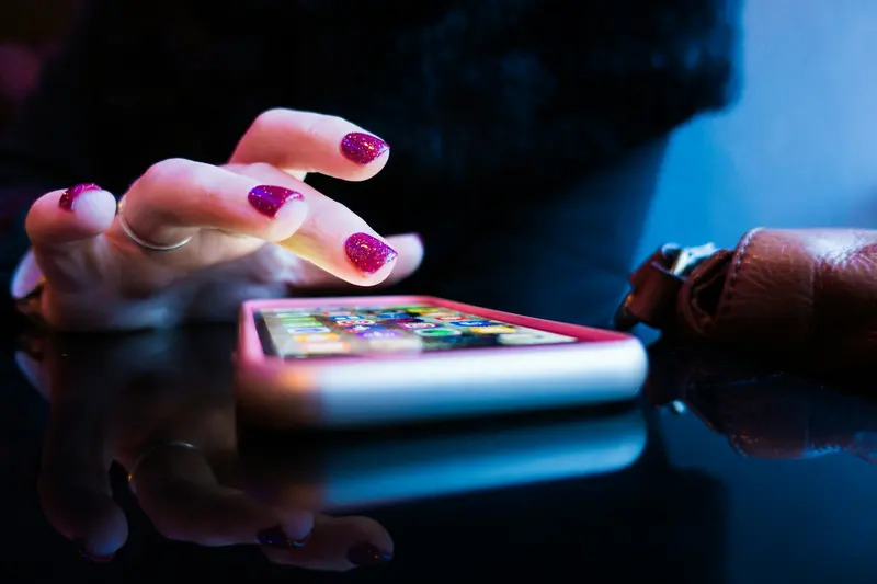 Person holding a smartphone in a dimly lit space