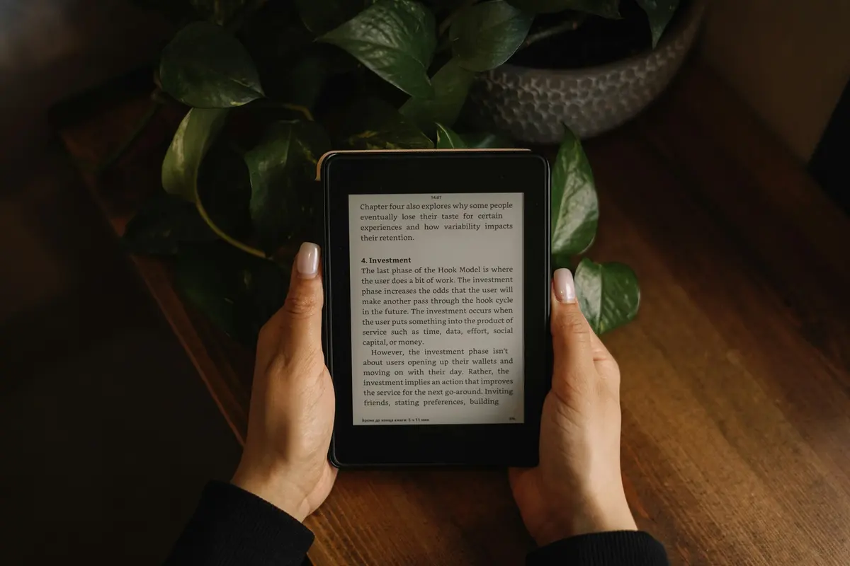 Person holding an e-reader at a table