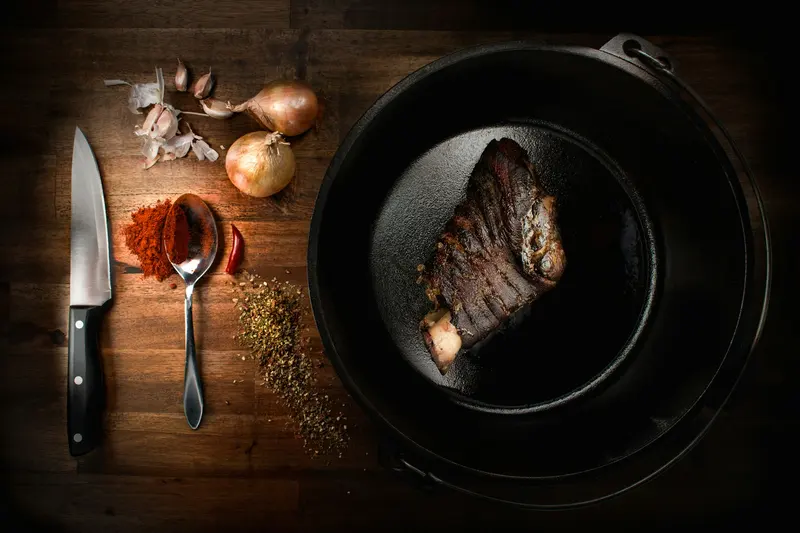 A steak cooking in a cast iron skillet