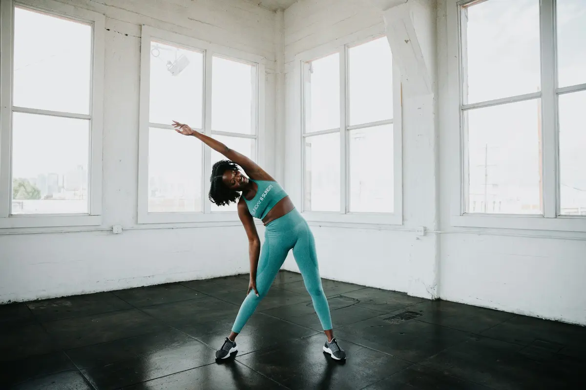 Woman in a blue sports bra and leggings doing a yoga pose
