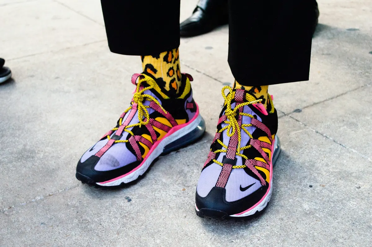 Person wearing black, blue and yellow sneakers